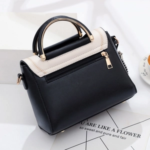Chic black and white color-block handbag with golden metal handle and zip pocket