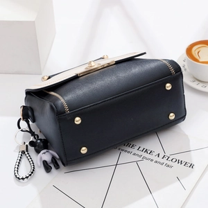 Chic black and white crossbody handbag with gold hardware and teddy bear charm accessory