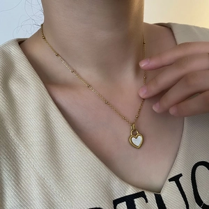 Gold plated heart pendant necklace with white mother of pearl inlay on model