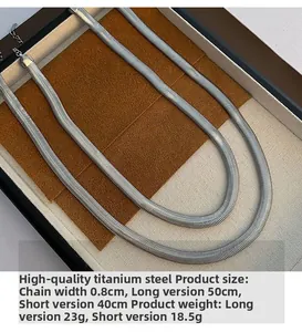 Detail of silver flat snake chain necklaces in premium titanium steel on a jewelry tray