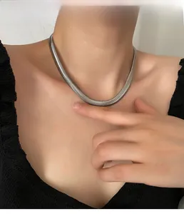 Close-up of thick silver herringbone snake chain necklace on a model's neck