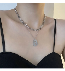 Close-up of double layer silver stainless steel chain with geometric hollow pendant