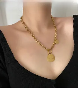 Close-up of gold titanium necklace featuring OT clasp and engraved grandmother round pendant