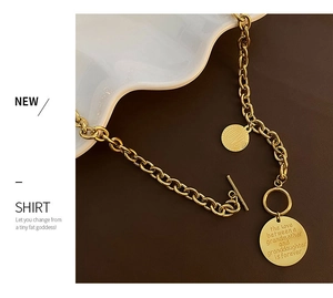 Detail of gold titanium steel chain necklace with OT buckle and LOVE engraved coin pendants