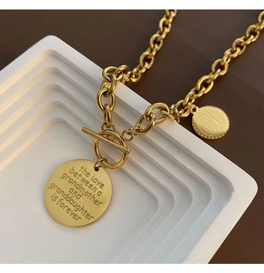 Detail of gold chain necklace with OT toggle clasp and engraved grandmother-granddaughter pendant