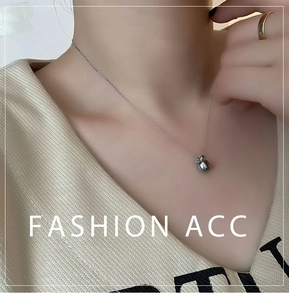 Détail d'un pendentif pomme poli sur un collier à chaîne perlée pour femme en argent