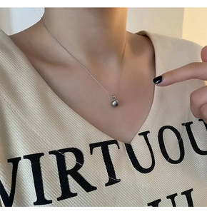 Détail du collier pendentif pomme argentée sur modèle avec chaîne à billes minimaliste