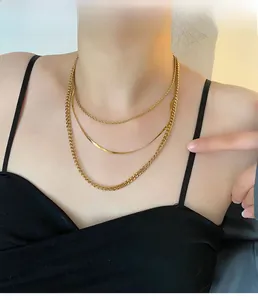 Detailed view of triple-layered gold stainless steel necklace on a model's neck