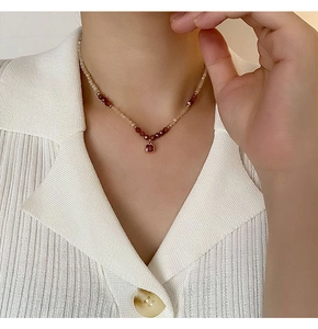 Detailed view of handmade pearl necklace with red garnet beads and square ruby pendant