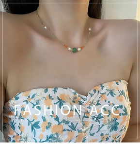 Close-up of pearl necklace with green zircon pendant on model neck bone