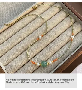 Detail of beaded necklace with green zircon and natural pearls in a jewelry display box