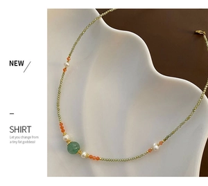 Detail of beaded necklace featuring green zircon, freshwater pearls, and gold spacers
