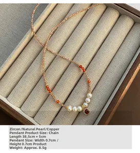 Detailansicht der Halskette mit rotem Zirkon und Süßwasserperle auf brauner Schmuckbox