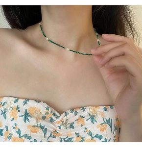 Detail of beaded necklace with green malachite, freshwater pearls and gold spacer beads