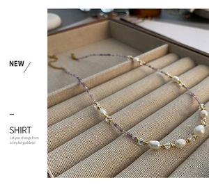 Detail of beaded necklace with purple zircon, pearls and gold spacers on velvet