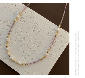 Detailed view of purple zircon beads and freshwater pearls on a titanium steel necklace