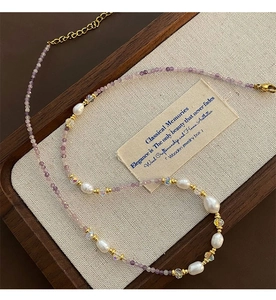 Detail of purple zircon and irregular pearls on a vintage gold-tone beaded necklace