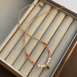 Elegante Perlenkette mit Süßwasserperlen und einem roten Edelsteinanhänger im Vintage-Stil
