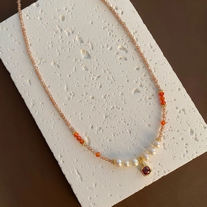 Elegante Süßwasserperlenkette mit orangefarbenen Perlen und rotem Edelstein-Anhänger in Gold