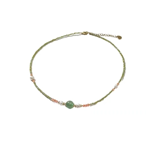 Beaded necklace with green gemstone pendant and freshwater pearls on white background