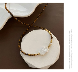 Collier en perles baroques avec perles œil de tigre et détails dorés sur présentoir