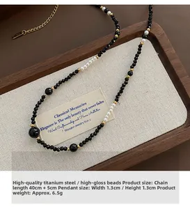 Detailed view of luxury black beaded necklace with white pearls and gold steel charms