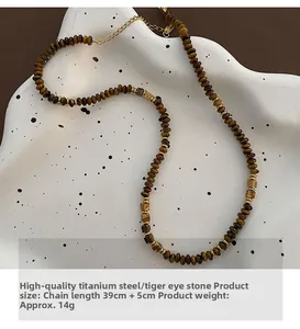 Detailed view of tiger eye stone beads and titanium steel gold spacers on a wavy ceramic tray