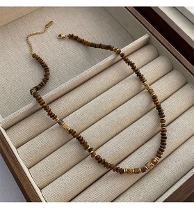 Detail of tiger eye stone necklace with gold beads and lobster clasp in jewelry box