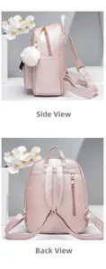 Detail view of pink PU leather backpack with gold zippers and plush fur pompom charm