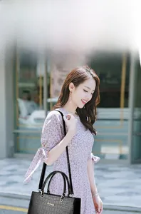 Sac à main luxe noir motif crocodile porté par un mannequin dans un cadre urbain