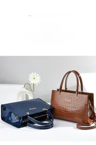 Détails des sacs en cuir verni à motif crocodile dans les tons bleu foncé et marron