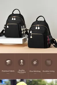Detail view of black oxford fabric backpacks with golden zippers and plaid side accents