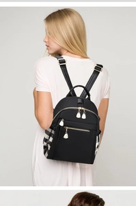 Detail view of black oxford backpack showing golden zipper and checkered side pocket