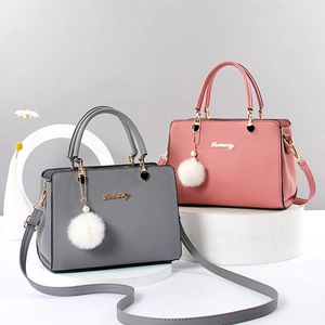 Modische Handtaschen aus Kunstleder in Grau und Rosa mit Pelzball-Anhängern