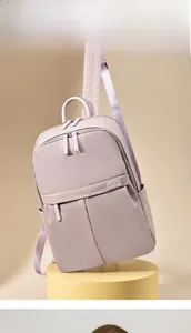 Detail view of the lilac backpack with satin texture and smooth metal zippers on a display