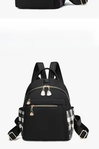 Front view of black oxford fabric backpack with checkerboard side pocket and gold zippers