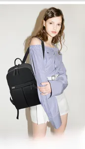 Small size black nylon backpack shown on model for travel and daily commute