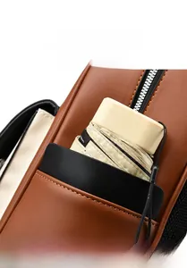 Détail d'un sac à dos en cuir marron avec une poche avant pour un parapluie