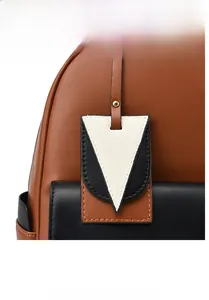 Détail de la poche avant montrant le cuir bicolore et le pendentif triangle élégant