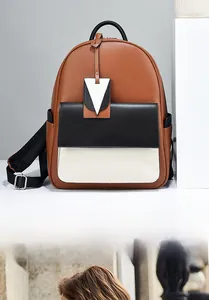Détail d'un sac à dos élégant en cuir tricolore avec panneaux marron, noir et blanc contrastés