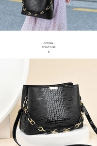 Detail of black embossed faux-crocodile bucket bag with chunky chain and leather strap