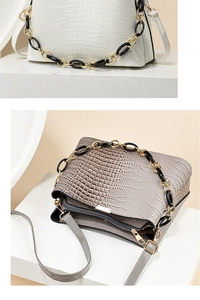 Detail of crocodile-embossed handbag featuring chic two-tone chain and interior compartments