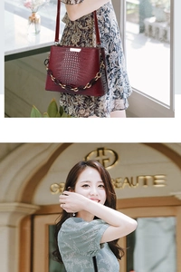 Detail of dark red crocodile embossed tote bag with acrylic chain and gold hardware