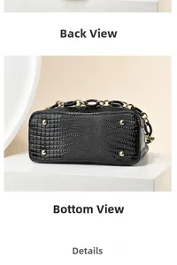 Detail view of black embossed bucket bag bottom with gold metal feet and chain strap