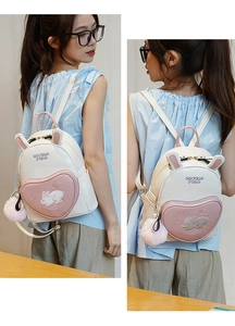 Close-up of mini rabbit backpack featuring pink heart pocket and plush ball detail