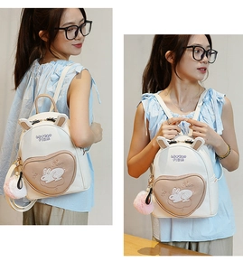 Detail showing white mini backpack with bunny ears and embroidered heart shaped pocket