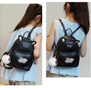 Detail of a mini black bunny backpack featuring 3D ears and heart-shaped zip pocket