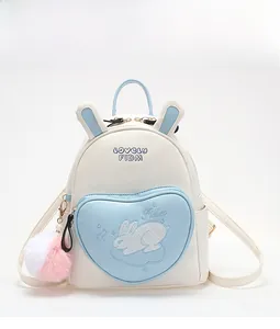 Front view of mini rabbit backpack featuring blue bunny ears and heart pocket details