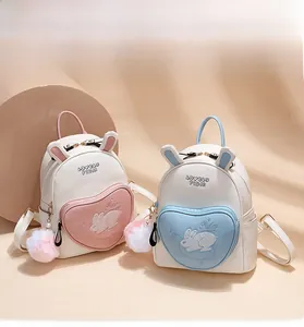 Detail of mini rabbit backpacks featuring heart zip pockets and plush pompom charms