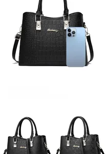 Detail view of black crocodile texture and monogram handbags with phone for scale